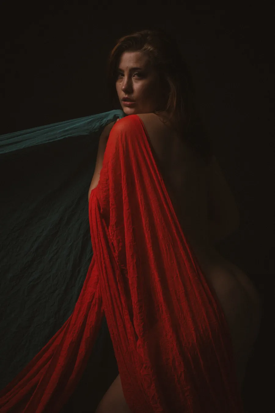 Figure wrapped in flowing red drape, fine art study